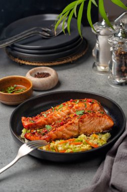 Lahanalı ballı sarımsaklı somon balığı, havuçlu dolmalık lahana salatası. Dikey resim.