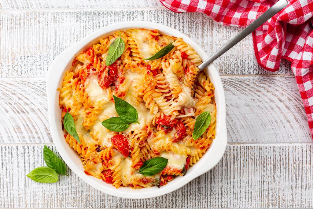 Pasta alla sorrentina.  Spiral shape fusilli pasta oven baked in casserole with tomato sauce, basil and mozzarella, parmigiano  cheese. Italian meal, Campania region.