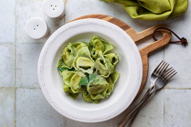Top view of Tortelloni  or tortelli Balanzoni - italian green pasta with Spinach and Ricotta cheese filling, with butter and sage.