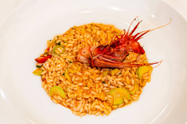 Ризотто с креветками и цуккини. Белая тарелка.