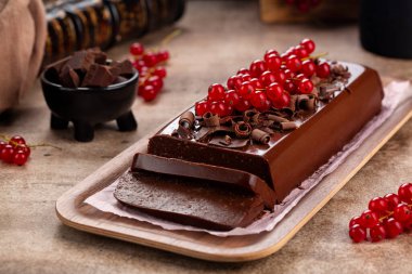 Chocolate Pudding Cake or Mousse Jiggly with gelatin and Amaretti, no bake dessert, decorated with red currant.
