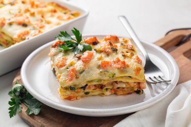 Lazanyayı somon balığı, kabak, beşamel sosu, parmesan peyniri ve pırasa ile kapat. Düz çarşaftan yapılmış fırında İtalyan makarnası..