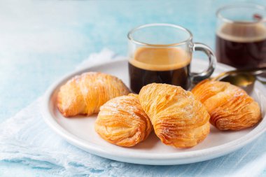 Kahveli İtalyan kahvaltısı. Caff Espresso ve nohut şekilli pasta sfogliatelle riccia ricotta, badem ezmesi ve şekerli citron ile doldurulmuş. Ya da ıstakoz kuyruğu. Açık mavi arkaplan.