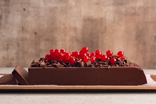 Italian Bonet or Dark Chocolate Pudding Cake or Mousse Jiggly with gelatin and Amaretti, no bake dessert, decorated with red currant. Copy space.