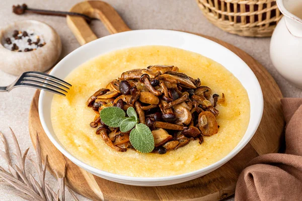 İtalyan polentası, mantar karışımı, şampiyon, porcini, pioppini, soğanla kızartılmış. Vejetaryen sonbahar yemeği..
