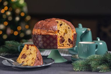 Panettone, İtalyan usulü tatlı ekmek. Aslen Milan 'dan. Çikolata şeklinde, kubbe şeklinde. Noel ve yeni yıl tatili için hazırlandı ve eğlendi. Çay zamanı. Neşeli ışıklar.