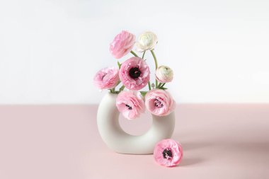 Seramik vazoda narin ranunculus çiçekleri