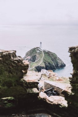 South Stack Deniz Feneri, Galler, Anglesey, İngiltere. Kutsal Ada 'nın kuzey-batı kıyısında küçük bir adanın zirvesine inşa edilmiştir. Gemileri aşağıdaki tehlikeli kayalara karşı uyarmak için 1809 'da inşa edildi..