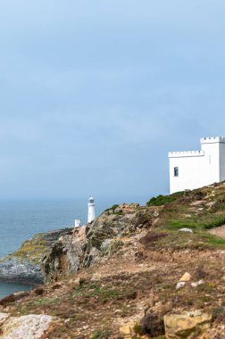 South Stack Deniz Feneri, Galler, Anglesey, İngiltere. Kutsal Ada 'nın kuzey-batı kıyısında küçük bir adanın zirvesine inşa edilmiştir. Gemileri aşağıdaki tehlikeli kayalara karşı uyarmak için 1809 'da inşa edildi..