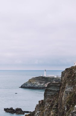South Stack Deniz Feneri, Galler, Anglesey, İngiltere. Kutsal Ada 'nın kuzey-batı kıyısında küçük bir adanın zirvesine inşa edilmiştir. Gemileri aşağıdaki tehlikeli kayalara karşı uyarmak için 1809 'da inşa edildi..