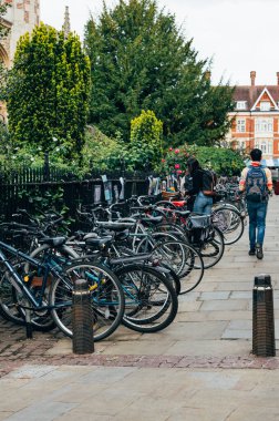 Cambridge, Cambridgeshire, Birleşik Krallık - 01 Haziran 2022: Kings College yakınlarındaki şehir merkezi caddeler, bisikletliler park etmiş ve öğrenciler yürüyor