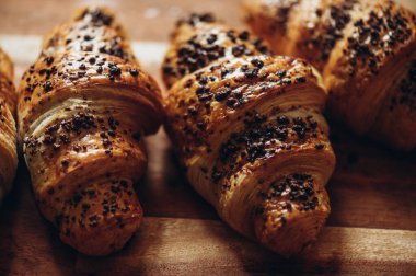 Ev yapımı çikolatalı kruvasan. Evdeki tavada pişmiş çikolata parçacıkları. Tahtaya atılmış.