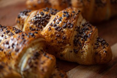 Ev yapımı çikolatalı kruvasan. Evdeki tavada pişmiş çikolata parçacıkları. Tahtaya atılmış.