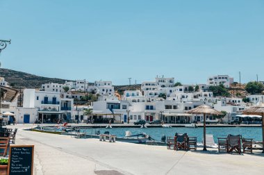 Panormos, Tinos, Greece: July 13, 2022 - Bay and village of Panormos with Cycladic houses, crystal clear water of the Aegean Sea and fishing boats on Tinos island, Cyclades, Greece