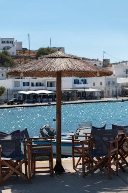 Panormos, Tinos, Greece: July 13, 2022 - Bay and village of Panormos with Cycladic houses, crystal clear water of the Aegean Sea and fishing boats on Tinos island, Cyclades, Greece