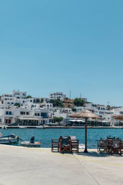 Panormos, Tinos, Greece: July 13, 2022 - Bay and village of Panormos with Cycladic houses, crystal clear water of the Aegean Sea and fishing boats on Tinos island, Cyclades, Greece