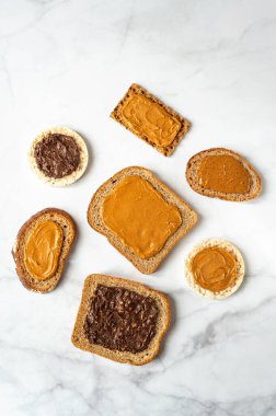 Various kind of bread, such as wholegrain, rice crakers, crispbreads and different nut butter, such as peanut, crunchy cashew and almond butter