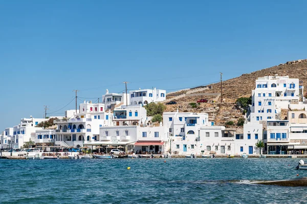 Panormos, Tinos, Greece: July 13, 2022 - Bay and village of Panormos with Cycladic houses, crystal clear water of the Aegean Sea and fishing boats on Tinos island, Cyclades, Greece