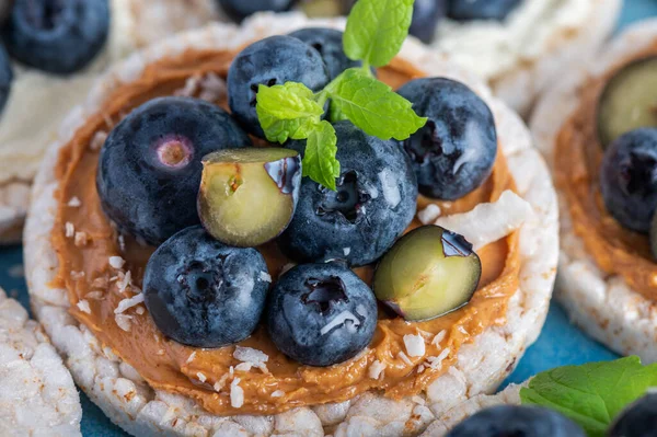 Open sandwich with blueberries. Made from rice crispbreads and peanut butter, healthy nutritious snack option, vegan food