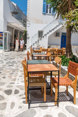Tinos, Greece: July 17, 2022: City centre and streets of village of Tinos with Cycladic houses, cafe and shops on Tinos island, Cyclades, Greece