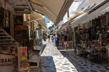 Tinos, Greece: July 17, 2022: City centre and streets of village of Tinos with Cycladic houses and shops on Tinos island, Cyclades, Greece