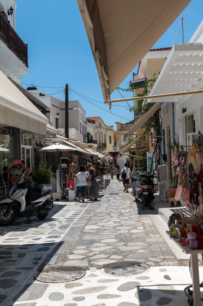 Tinos, Greece: July 17, 2022: City centre and streets of village of Tinos with Cycladic houses and shops on Tinos island, Cyclades, Greece