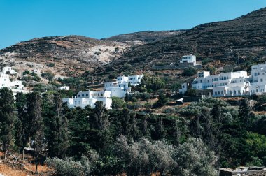 Tinos, Greece: July 13, 2022: White Cycladic houses on the hill on Tinos island, Cyclades, Greece