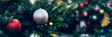 Christmas and New Year time, amazing Xmas decorations on pine trees with real snow, blurred background, banner size