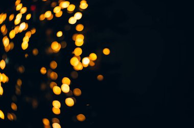 Siyah izole edilmiş arka planda Noel ışıklarından yapılan sarı soyut bokeh. Tatil konsepti, bulanık bokeh, resimleriniz için örtüşür.