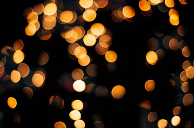 Siyah izole edilmiş arka planda Noel ışıklarından yapılan sarı soyut bokeh. Tatil konsepti, bulanık bokeh, resimleriniz için örtüşür.