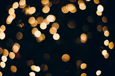Siyah izole edilmiş arka planda Noel ışıklarından yapılan sarı soyut bokeh. Tatil konsepti, bulanık bokeh, resimleriniz için örtüşür.