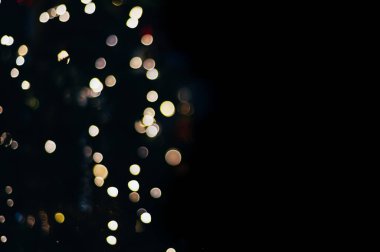 Siyah izole edilmiş arka planda Noel ışıklarından yapılmış renkli soyut bir Bokeh. Tatil konsepti, bulanık bokeh, resimleriniz için örtüşür.