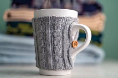 Katlanmış yün battaniye yığını ve Wollen kılıfında kupa, sonbahar ve soğuk kış konsepti