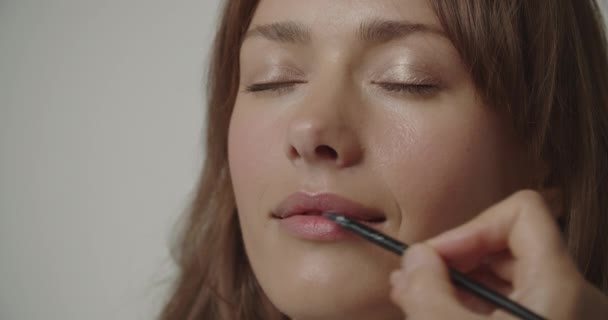 Молода жінка закриває очі як макіяж застосовується — стокове відео