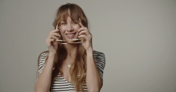 Mulher jovem com cabelos longos experimentando óculos — Vídeo de Stock