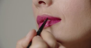 Ruju fırçayla sürülen genç bir kadın.