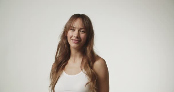Gyönyörű fiatal nő fehér mellényt visel — Stock videók