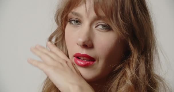 Vrouw veegt haar rode lippenstift over haar gezicht — Stockvideo