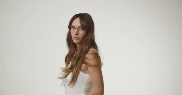 Mujer con el pelo largo en chaleco blanco y gafas — Vídeos de Stock