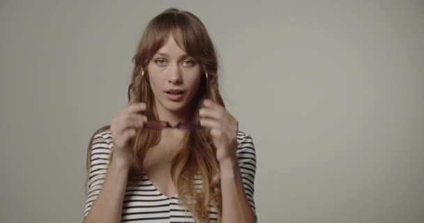 Молода жінка з довгим волоссям намагається на окулярах — стокове відео