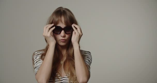 Młoda kobieta z długimi włosami przymierzając okulary — Wideo stockowe