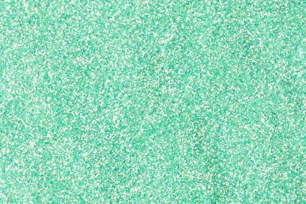 Holographic glitter background with shiny surface, texture in greeny tone. — Stockfoto