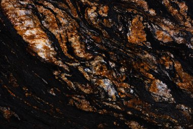Natural Black Magma granite texture in dark color with brown surface.