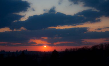 Şehrin üzerinde alacakaranlık olan arka plan, son ışınlar. Duygusal gün batımı, başkent Prag üzerindeki manzara. Doğal fenomen.