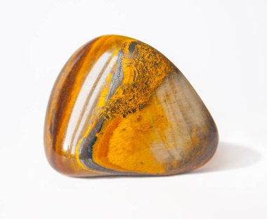 Altın renkli, yarı değerli taş Jasper. Makro. Portakal sarısı çizimli mineral. Beyaz arkaplanda gölgeli tek taş.