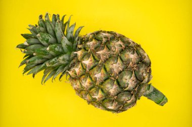 Sarı arka planda ananas.