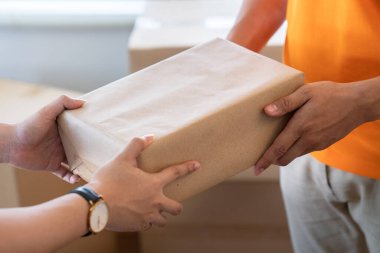 Genç adam kuryenin elinden bir paket alır..