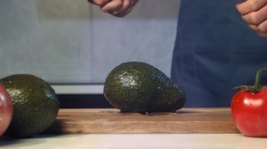 Şef avokadoyu yavaş çekimde kesiyor, avokadoyu yakın çekimde dilimliyor, avokado yavaş çekimde düşüyor, avokadoyu yakın çekimde düşürüyor.