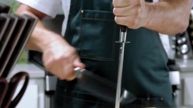 Şef bıçağı yavaş çekimde keskinleştirir, şef mutfak restoranında bıçağı biler, şef yemek pişirmeden önce bıçağı biler.