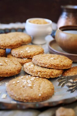 Çıtır yulaflı kurabiye, kahve molası için bir fincan kahve ahşap arka planda.